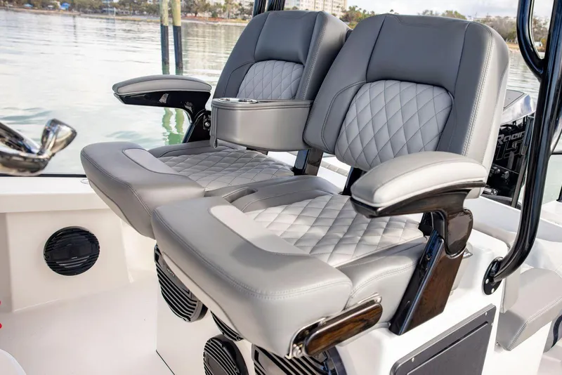 Slide: The Image of Luxury seating on 2026 Calcutta 263 boat, featuring quilted gray upholstery and armrests. - 11