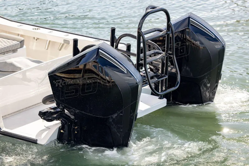 Slide: The Image of Twin black outboard motors on a 2026 Calcutta 263 boat in water. - 7