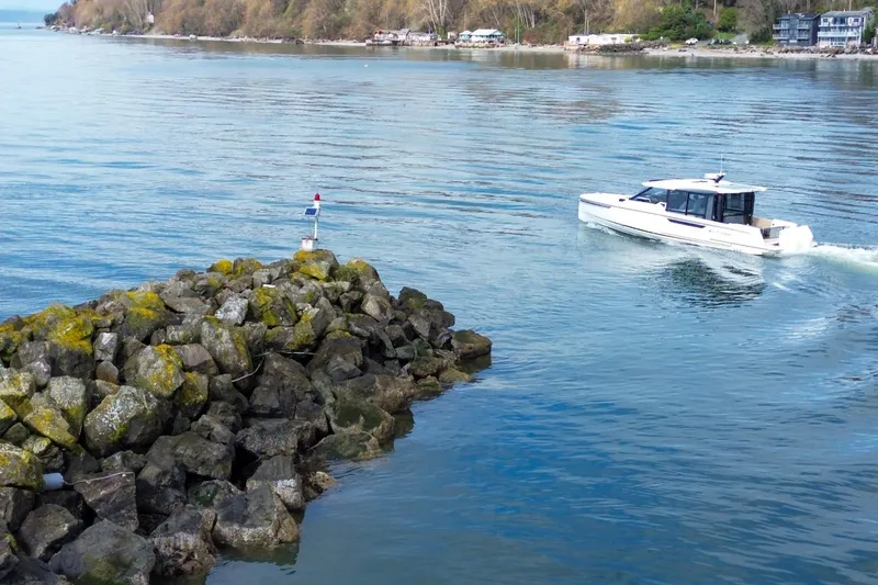 Slide: The Image of 2026 Saxdor 400 GTC cruising near rocky shoreline on a calm day. - 11