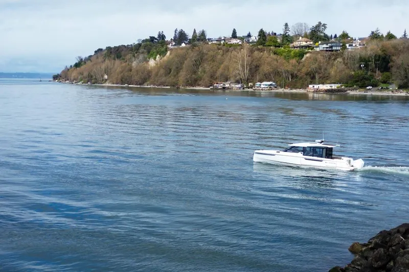 Slide: The Image of Saxdor 400 GTC 2026 cruising near a scenic coastline with houses and trees. - 12