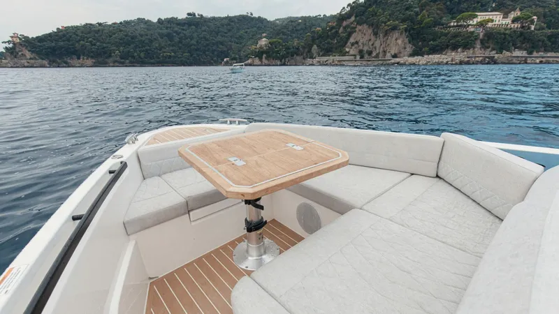 Slide: The Image of Luxurious seating area on the 2025 Saxdor 400 GTC boat with scenic coastal backdrop. - 14