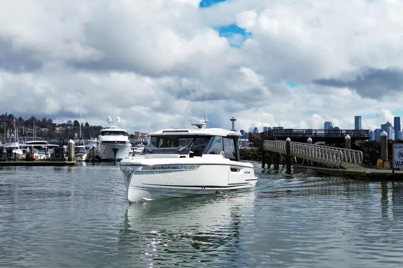 Slide: The Image of 2026 Saxdor 400 GTC boat cruising in a marina with city skyline backdrop. - 2