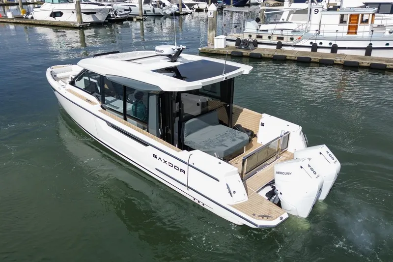 Slide: The Image of 2026 Saxdor 400 GTC luxury boat docked in marina, featuring sleek design and twin Mercury engines. - 6