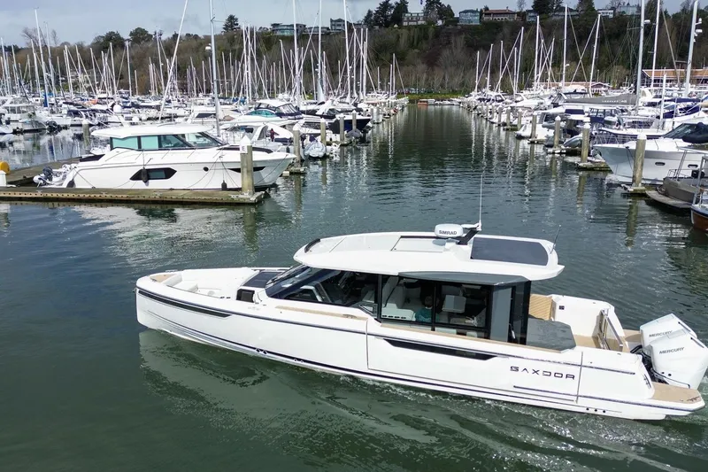 Slide: The Image of 2026 Saxdor 400 GTC luxury boat docked in a marina with numerous sailboats. - 9
