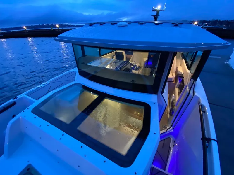 Slide: The Image of 2025 Saxdor 320 GTC boat docked at twilight with illuminated interior. - 11
