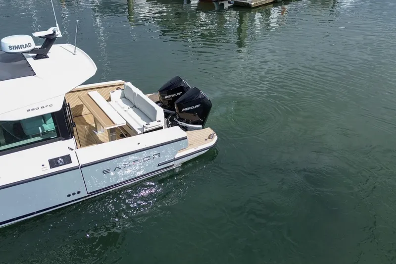Slide: The Image of 2026 Saxdor 320 GTC boat with dual Mercury engines docked on calm water. - 3
