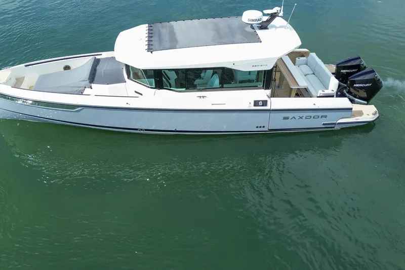 Slide: The Image of 2026 Saxdor 320 GTC boat on water, featuring sleek design and dual Mercury engines. - 4