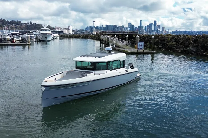 Slide: The Image of 2026 Saxdor 320 GTC boat cruising near marina with city skyline in background. - 5