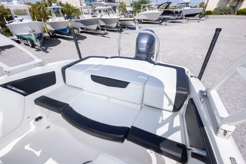 Slide: The Image of 2017 Chaparral 21 H2O Sport boat interior with seating and motor, surrounded by other boats. - 16