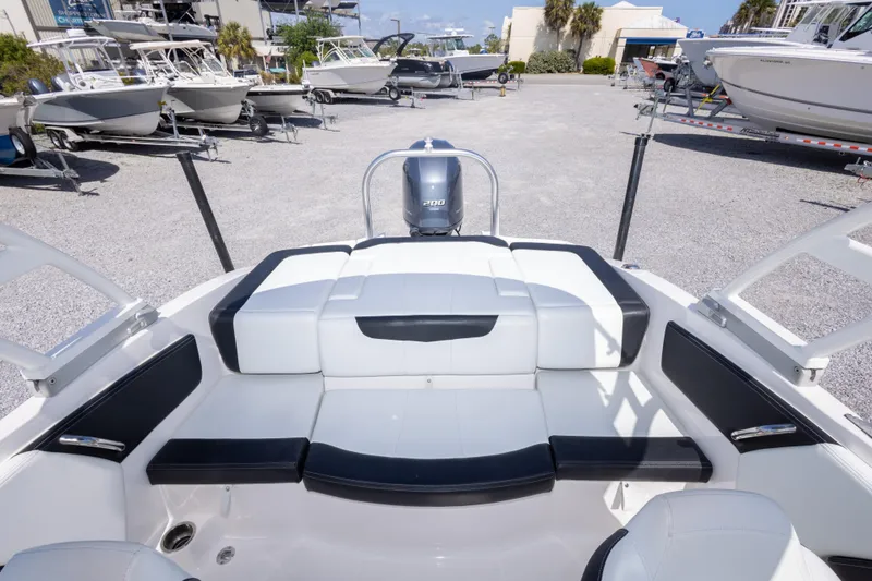 Slide: The Image of 2017 Chaparral 21 H2O Sport boat interior with seating, parked among other boats. - 17
