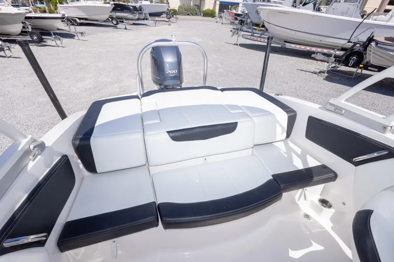 Slide: The Image of 2017 Chaparral 21 H2O Sport boat interior with cushioned seating and outboard motor. - 18