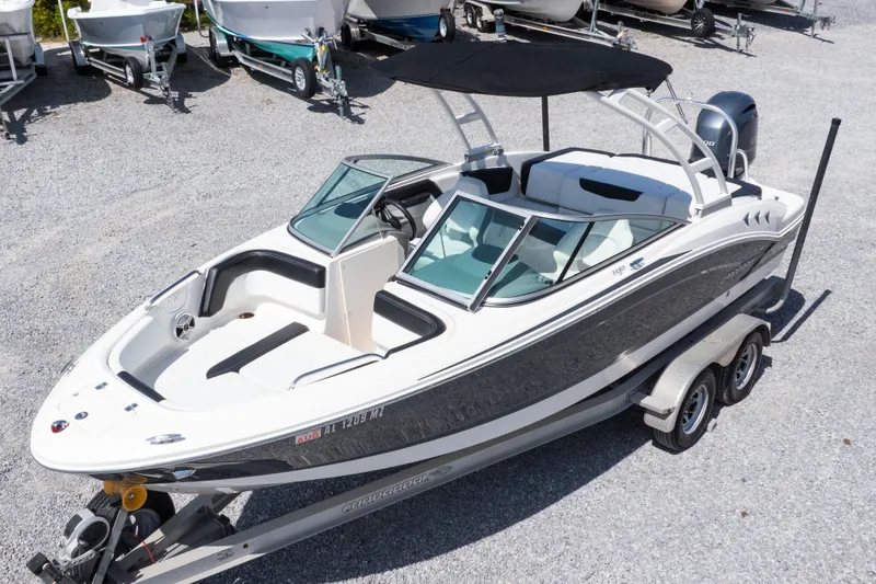 Slide: The Image of 2017 Chaparral 21 H2O Sport boat on trailer, parked in gravel lot. - 2