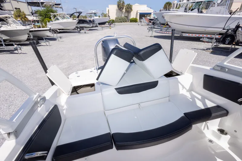 Slide: The Image of 2017 Chaparral 21 H2O Sport boat interior with white and black seating in a marina. - 20