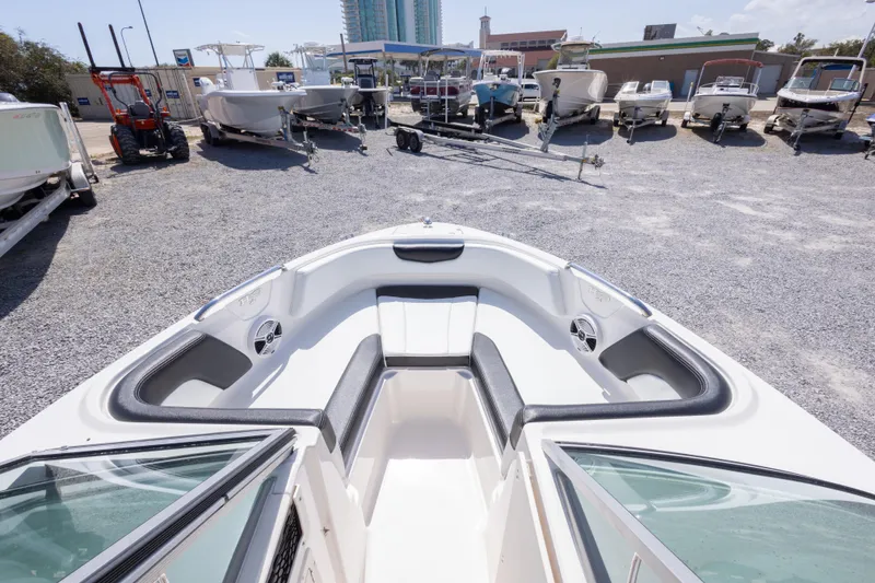 Slide: The Image of 2017 Chaparral 21 H2O Sport boat interior with seating, parked among other boats. - 30