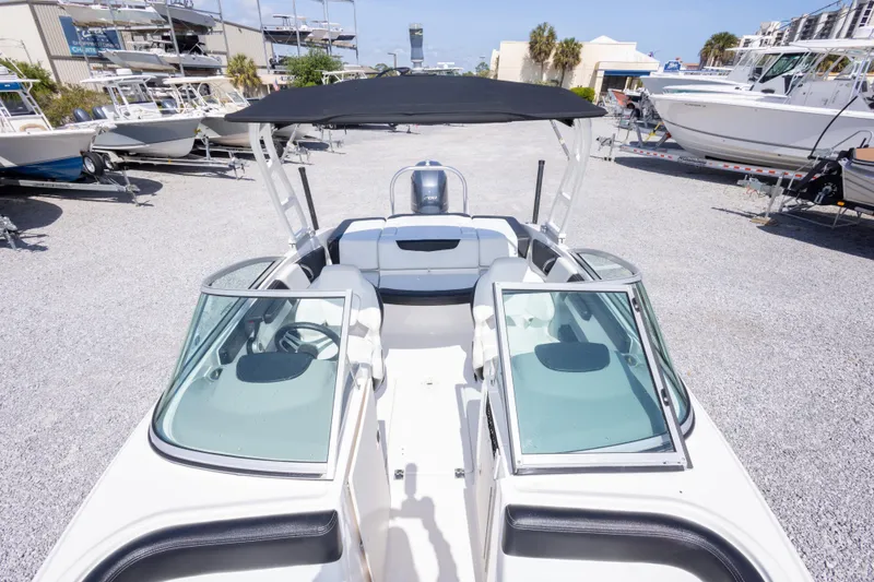 Slide: The Image of 2017 Chaparral 21 H2O Sport boat with black canopy in a marina setting. - 31