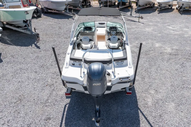 Slide: The Image of 2017 Chaparral 21 H2O Sport boat with Yamaha 200 engine, parked on gravel lot. - 37