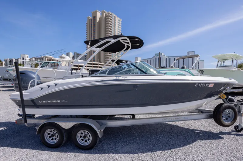 Slide: The Image of 2017 Chaparral 21 H2O Sport boat on trailer, urban backdrop, sunny day. - 9
