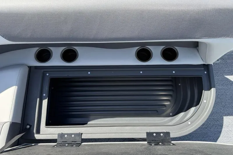 Slide: The Image of 2026 Sun Tracker Bass Buggy 18 DLX interior storage compartment with cup holders. - 23
