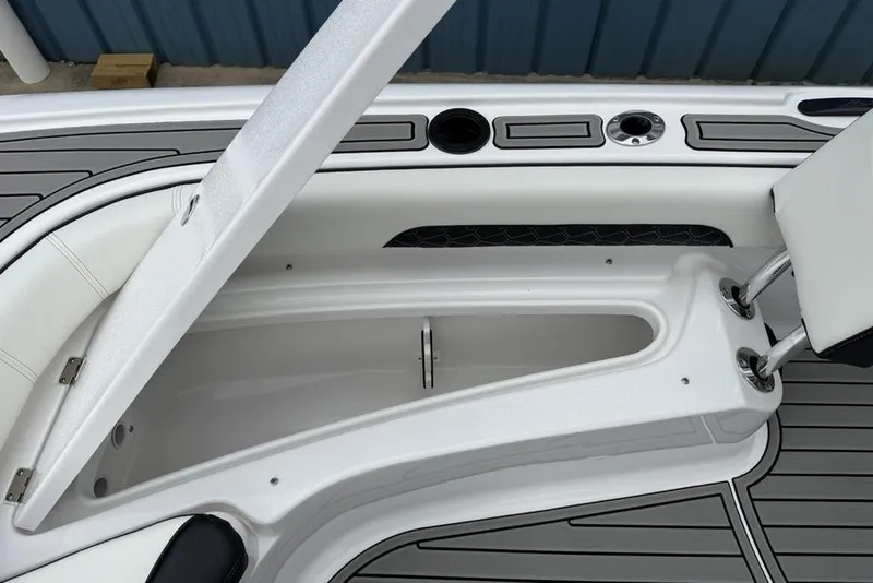 Slide: The Image of 2026 Tidewater 2500 Carolina Bay boat interior storage compartment with sleek design and cup holders. - 19