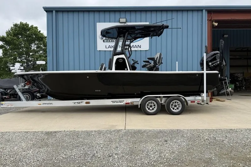 The Image of 2026 Tidewater 2500 Carolina Bay boat on trailer outside marine shop. - 2