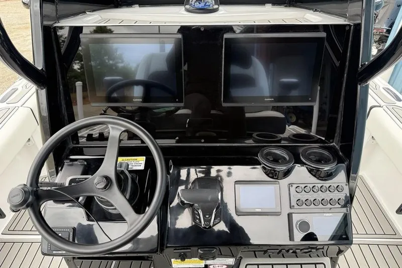 Slide: The Image of Steering console of 2026 Tidewater 2500 Carolina Bay boat with dual screens and controls. - 22