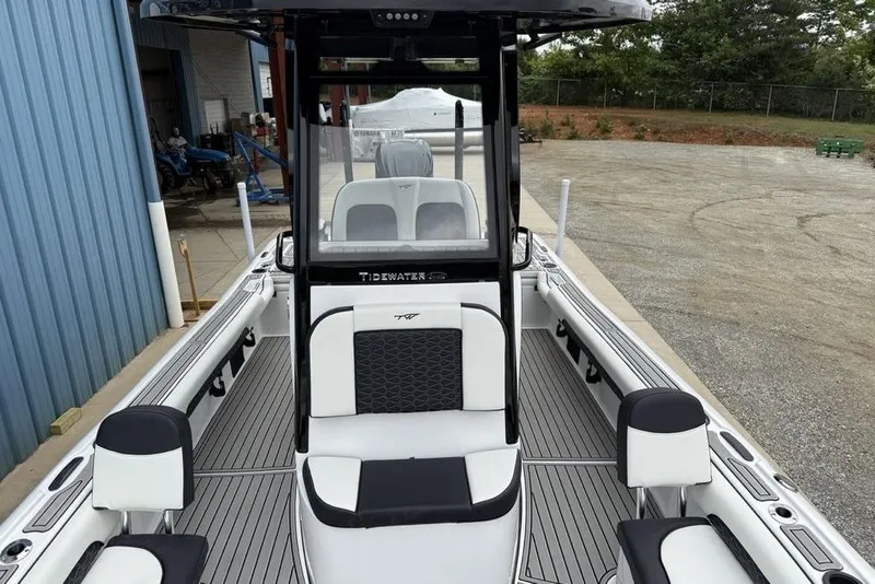 Slide: The Image of 2026 Tidewater 2500 Carolina Bay boat interior with seating and console, docked outdoors. - 24