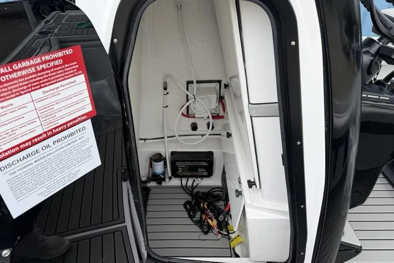 Slide: The Image of Interior view of 2026 Tidewater 2500 Carolina Bay boat compartment with equipment and warning signs. - 47