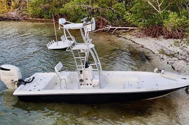 Slide: The Image of 2009 ShearWater 2400Z boat with Suzuki engine, docked near lush shoreline. - 12