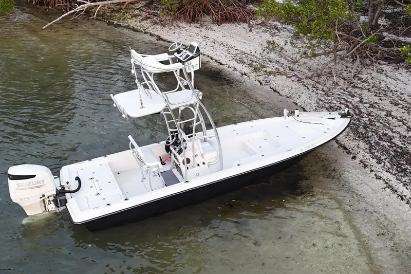 Slide: The Image of 2009 ShearWater 2400Z boat with Suzuki engine, docked on a sandy shoreline. - 13