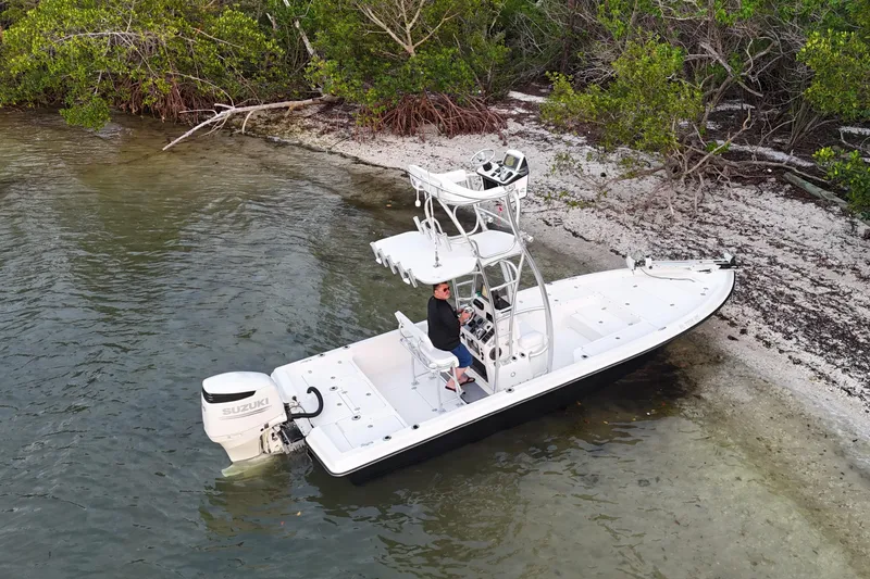 Slide: The Image of 2009 ShearWater 2400Z boat near shoreline with Suzuki outboard motor. - 14