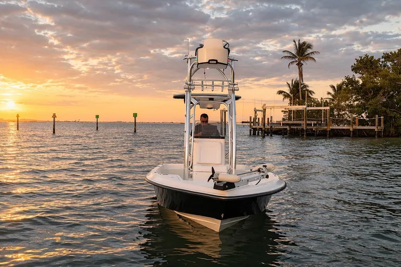 Slide: The Image of 2009 ShearWater 2400Z boat on water at sunset with palm trees in background. - 2