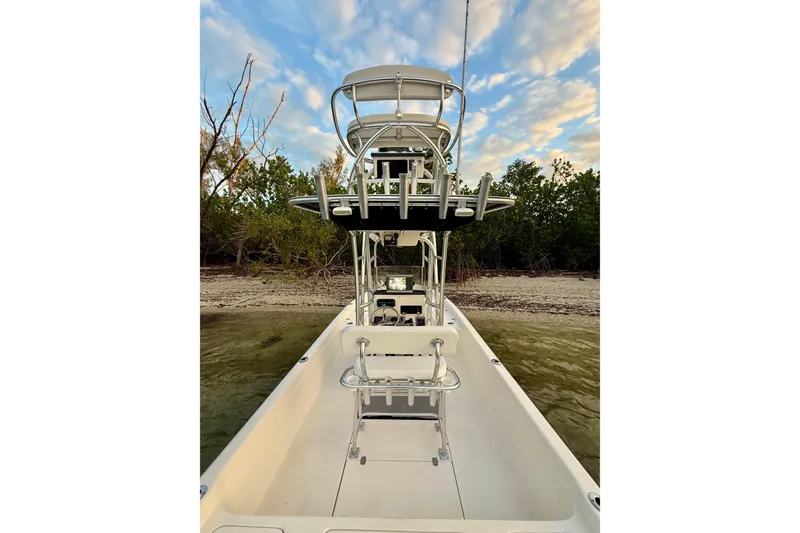 Slide: The Image of 2009 ShearWater 2400Z boat docked near shoreline under a cloudy sky. - 21