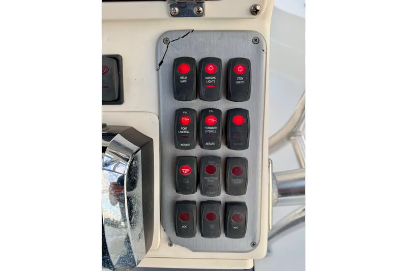 Slide: The Image of Control panel of a 2009 ShearWater 2400Z boat with various switches and indicators. - 24