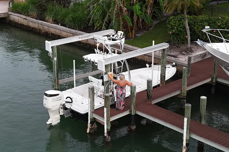 Slide: The Image of A 2009 ShearWater 2400Z boat docked with a Suzuki engine, surrounded by lush greenery. - 31