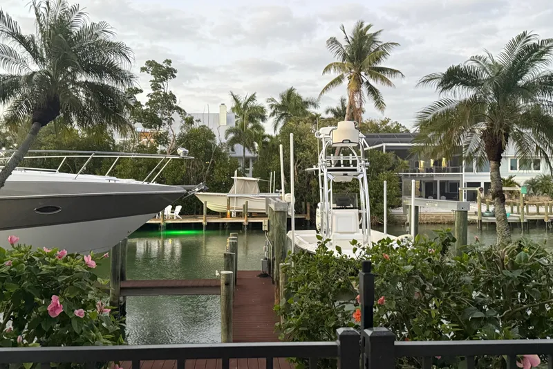 Slide: The Image of Tropical waterfront scene with boats, including a 2009 ShearWater 2400Z, surrounded by palm trees. - 33