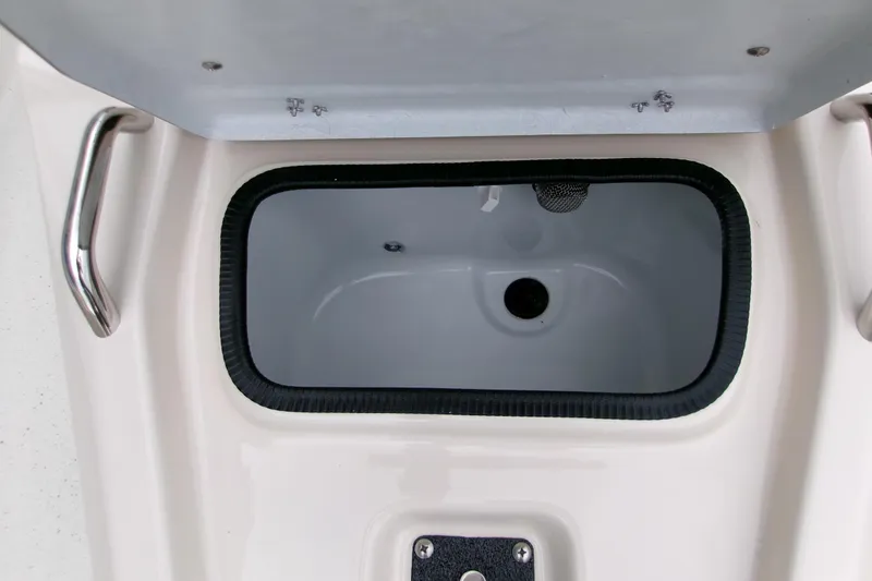 Slide: The Image of Open storage compartment on 2026 Xpress H22B Bay boat, featuring stainless steel handle. - 12
