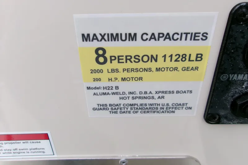 Slide: The Image of 2026 Xpress H22B Bay boat capacity label, 8 persons, 1128 lbs, 200 HP motor. - 3