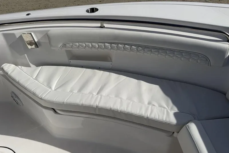 Slide: The Image of 2026 Tidewater 232 LXF boat interior with white cushioned seating and elegant stitching. - 12
