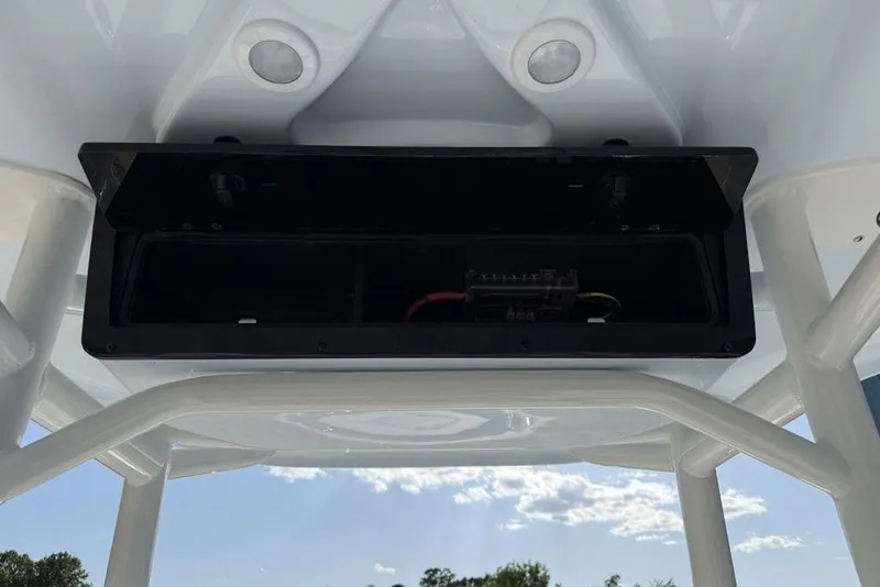 Slide: The Image of Open storage compartment on 2025 Tidewater 2210 Carolina Bay boat, under clear blue sky. - 5