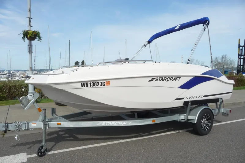Slide: The Image of 2022 Starcraft SVX 171 OB boat on trailer, parked near marina. - 1