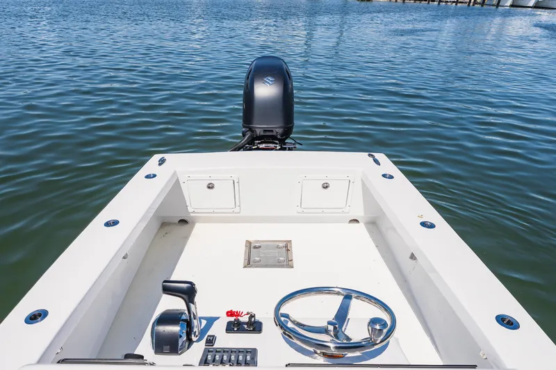 Slide: The Image of 1979 Privateer 20 boat with steering wheel and controls on calm water. - 13