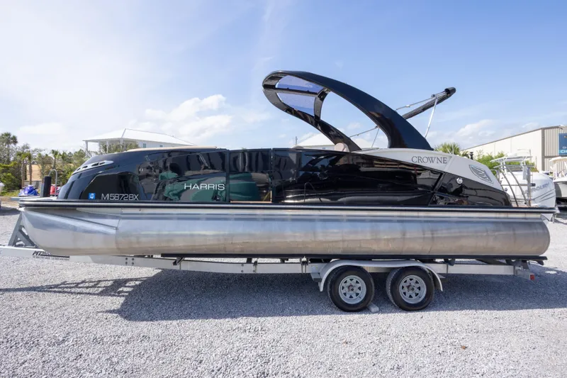 Slide: The Image of 2016 Harris Crowne 250 pontoon boat on trailer, parked outdoors. - 15