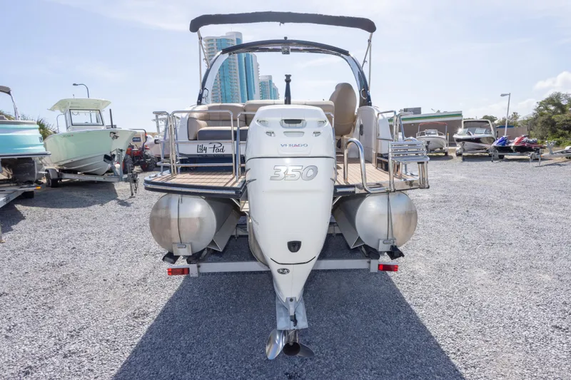 Slide: The Image of 2016 Harris Crowne 250 boat with powerful outboard motor, parked on gravel lot. - 18
