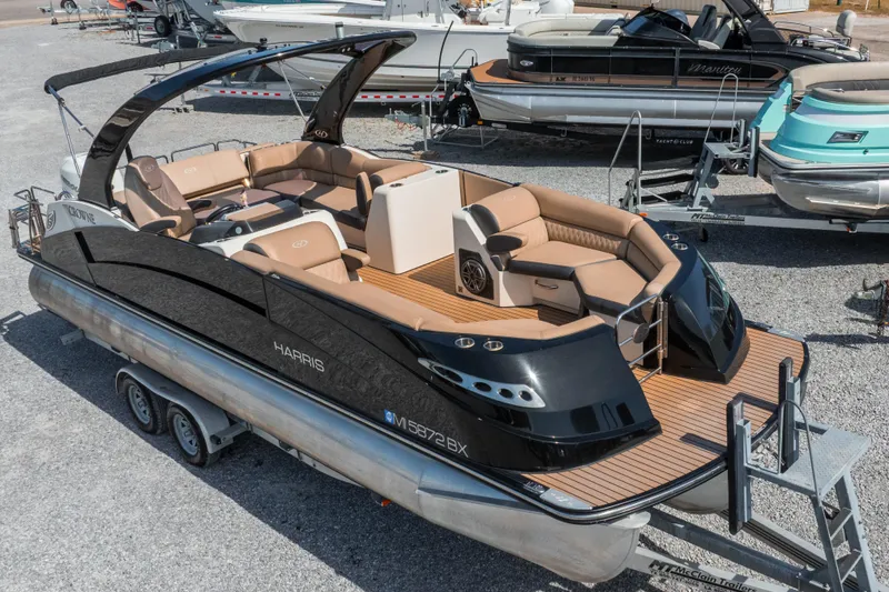 Slide: The Image of 2016 Harris Crowne 250 pontoon boat with luxurious seating and sleek design on a trailer. - 2