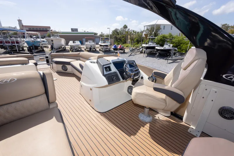 Slide: The Image of Luxurious 2016 Harris Crowne 250 pontoon boat interior with plush seating and modern helm. - 26