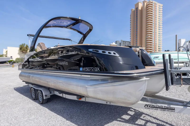 Slide: The Image of 2016 Harris Crowne 250 pontoon boat on trailer, urban backdrop. - 3