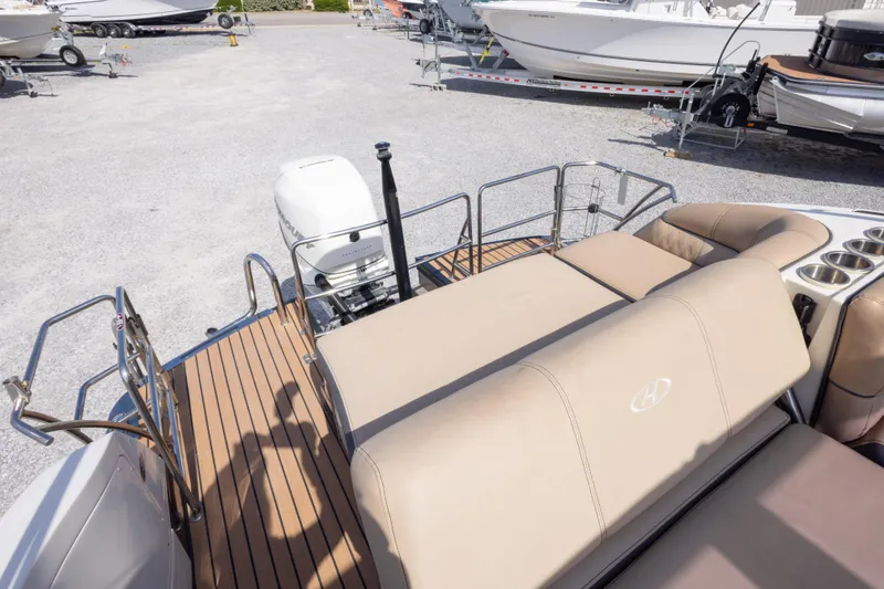 Slide: The Image of 2016 Harris Crowne 250 boat with beige seating and outboard motor in a marina. - 39