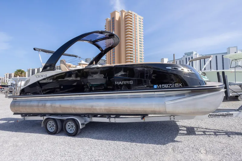 Slide: The Image of 2016 Harris Crowne 250 pontoon boat on trailer, urban backdrop. - 8