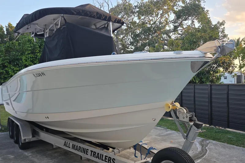 The Image of 2015 Robalo R300 Center Console boat on trailer, parked outdoors. - 0