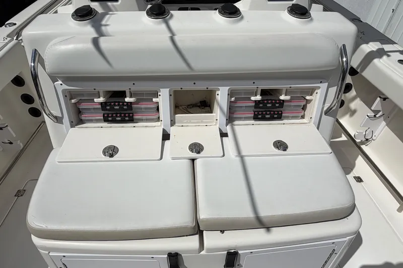 Slide: The Image of 2015 Robalo R300 Center Console boat with open storage compartments and cushioned seating. - 12